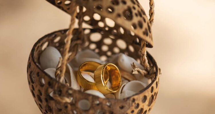 Close-up of golden wedding rings lying in the coconut shell